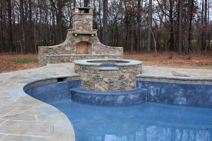 landscape design with swimming pool and outdoor fireplace